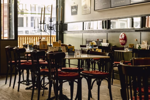 Empty café interior with wooden tables and chairs, menus and a candelabra